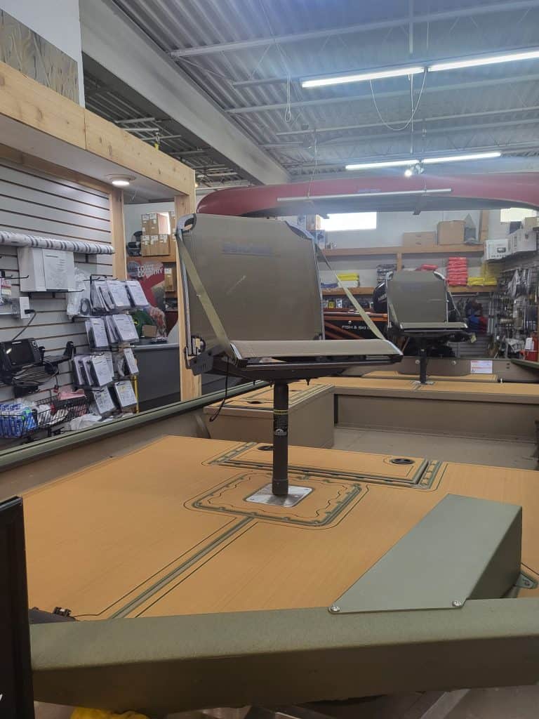Boat model display in retail store with accessories and equipment.
