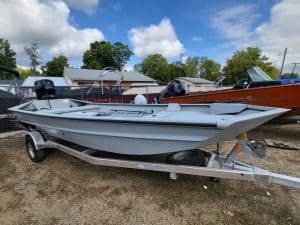 New 2024 SeaArk 1860-JT fishing boat on trailer at dealership.