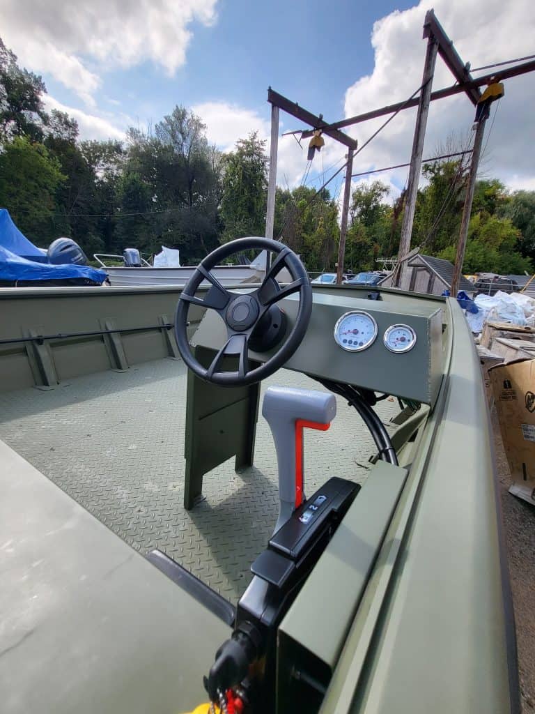 Outdoor boat cockpit with steering wheel, gauges, and control lever at Camp & Cruise.