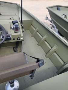 Close-up of boat interior with seating and control panel.