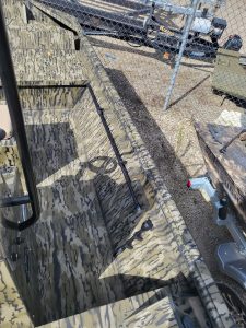 Camouflage boat interior with storage compartments and fishing rod holders.
