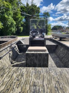 View of boat interior with steering wheel and windshield at Camp and Cruise.