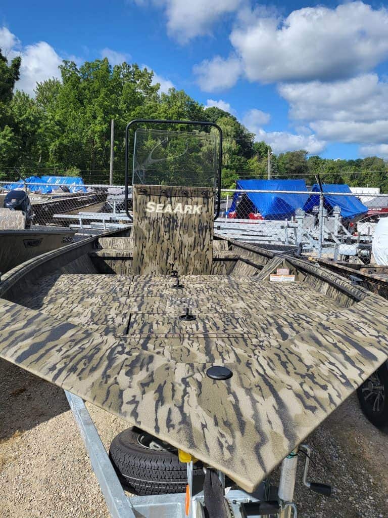 Camouflage boat deck with SeaArk logo at boat dealership.