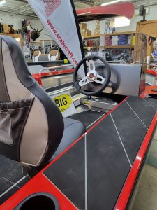 Close-up of boat interior with steering wheel and dashboard at Camp and Cruise.
