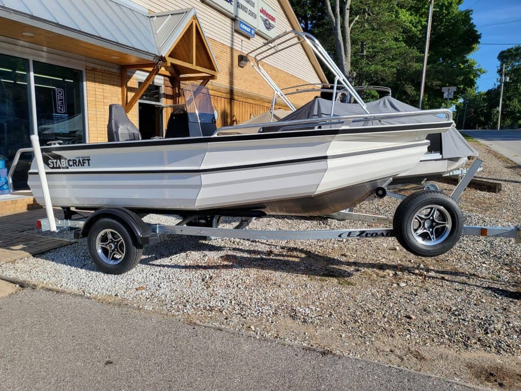 Starcraft 1450 Frontier Sportfish boat on trailer outside dealership.