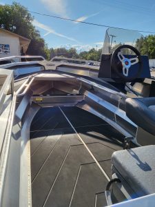 Aluminum boat with steering wheel and seating at Camp & Cruise offering quality boating experience.