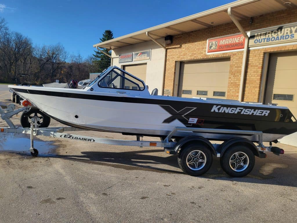 KingFisher 1975 Fastwater X9 boat on trailer outside dealership.