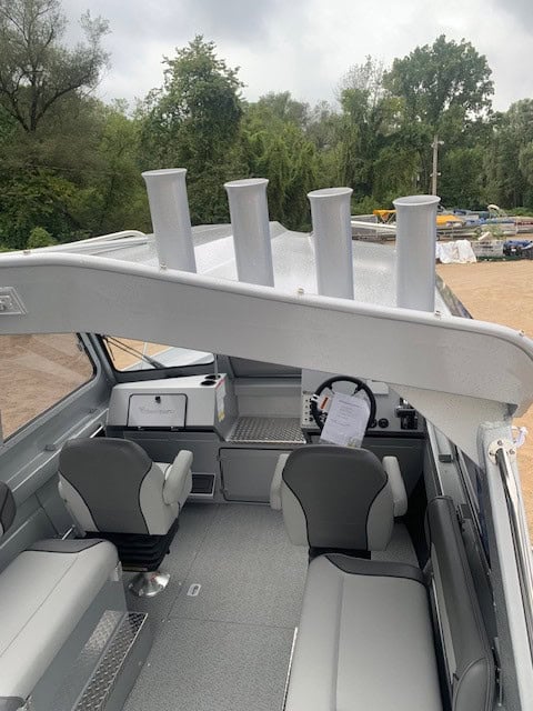Boat interior with multiple fishing rod holders and seating area.