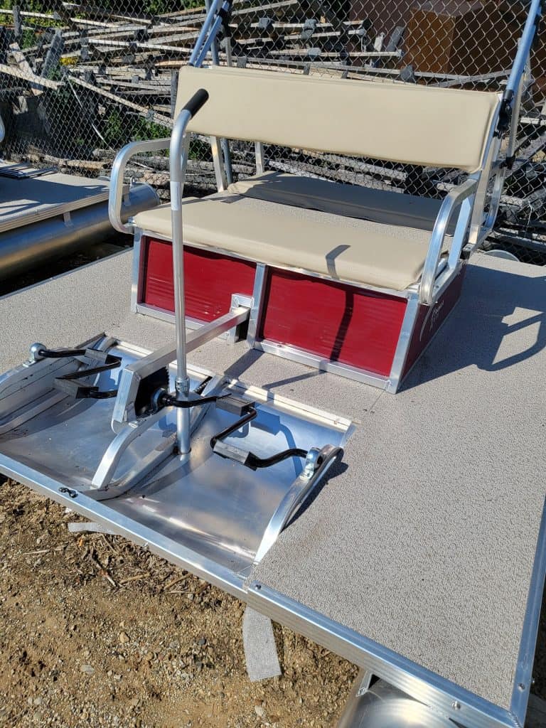 Golf cart seat with red storage and beige cushion on a metallic platform.