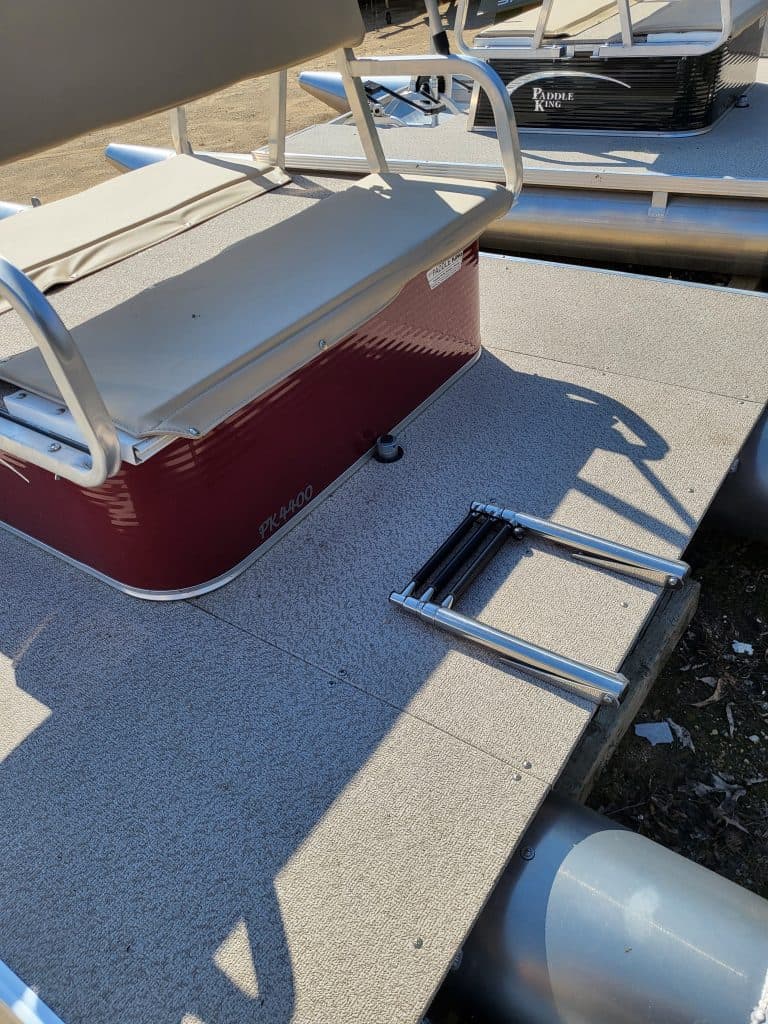 Paddle King PK 4400 pontoon boat on a dock with a step ladder.