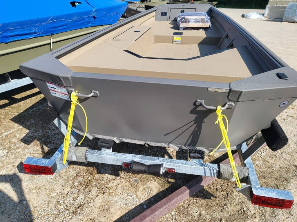 Durable boat on trailer with beige interior and gray exterior.