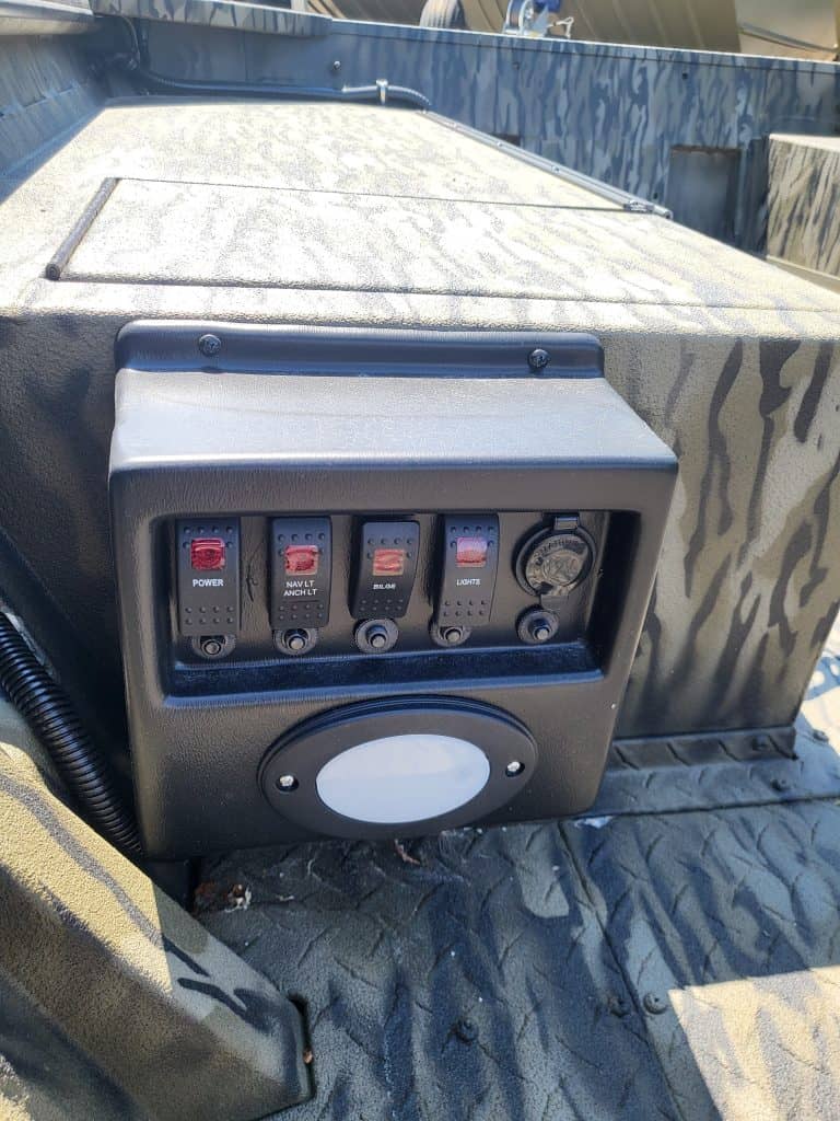 Boat control panel with switches and power outlet for marine applications.
