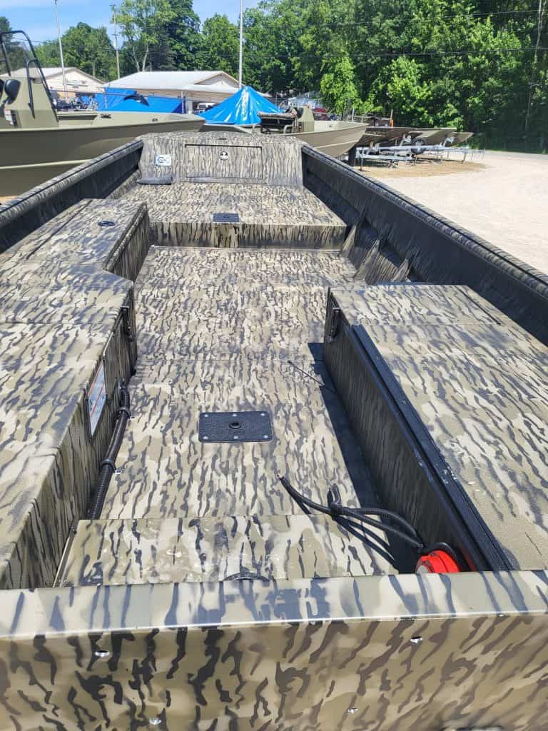 Camouflage boat deck with storage compartments and wiring.