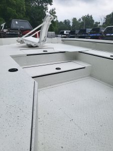 Close-up of boat deck with storage compartments and mounting hardware.