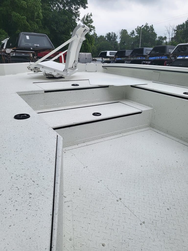 Close-up of boat deck with storage compartments and mounting hardware.