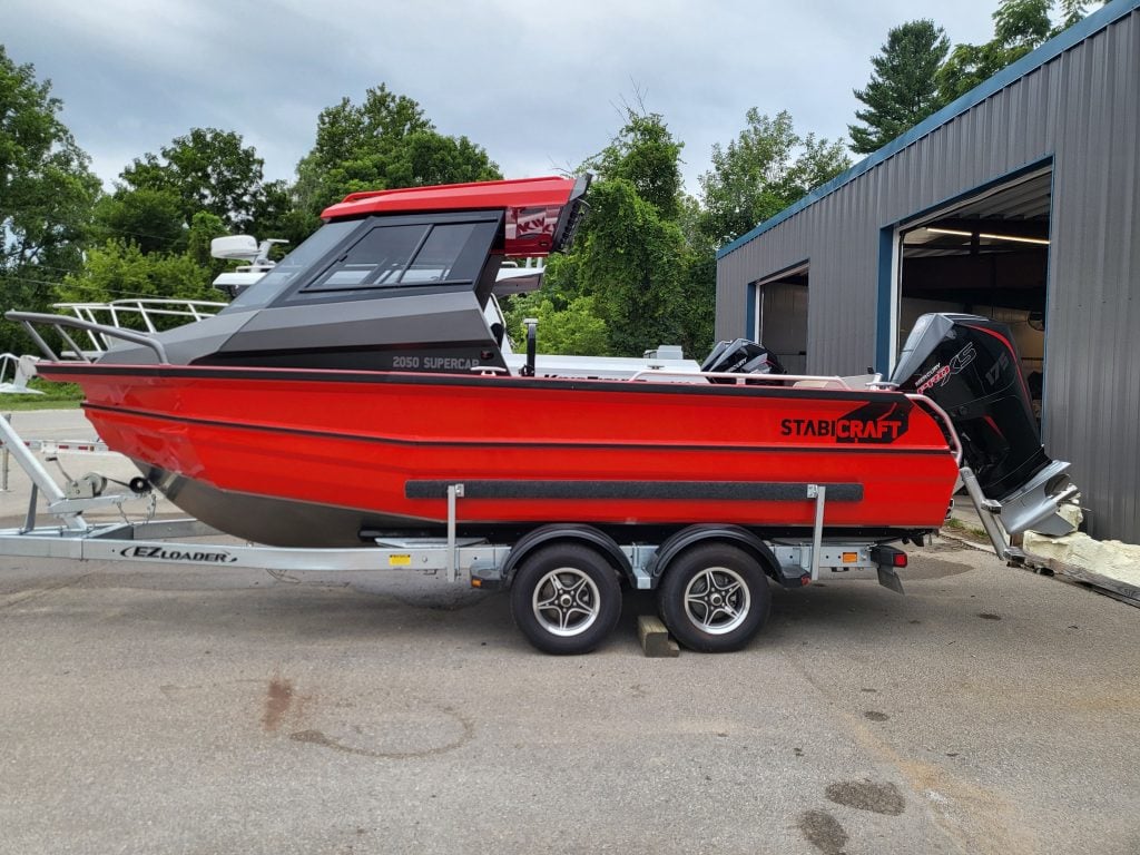 Red StabiCraft 2050 SuperCab boat on trailer with outboard motor.
