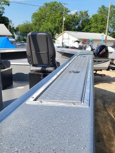 Aluminum boat deck with storage and seating for fishing or leisure.