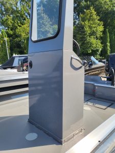 Boat console with windshield on a fishing boat at a marina.