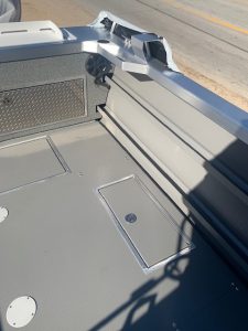 Boat deck with storage compartments and hardware details.