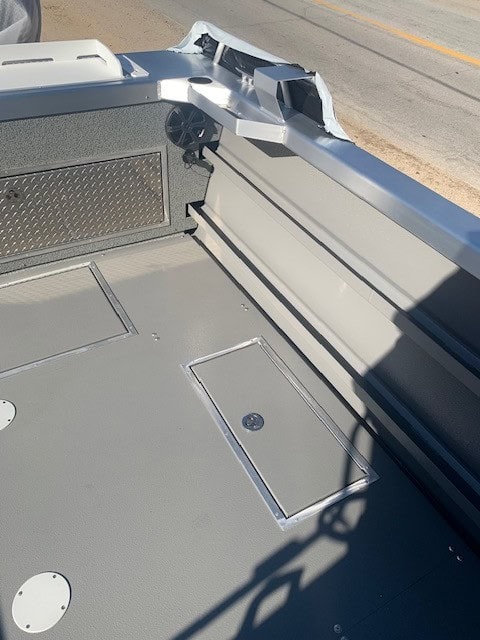 Boat deck with storage compartments and hardware details.