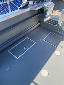 Boat deck with storage compartments and non-slip surface.