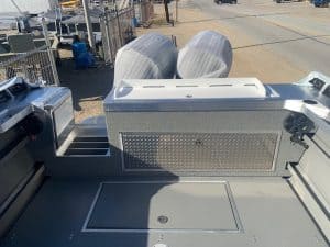 Boat deck with two outboard motors and storage compartments.