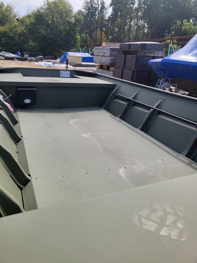 Aluminum boat with spacious interior, ideal for fishing and water sports at Camp & Cruise.