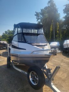Luxury boat with black and white canopy on trailer, perfect for water adventures.