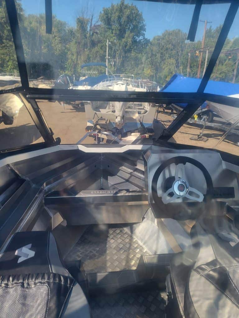 Boat cockpit with steering wheel and seating, perfect for water sports and recreational boating.