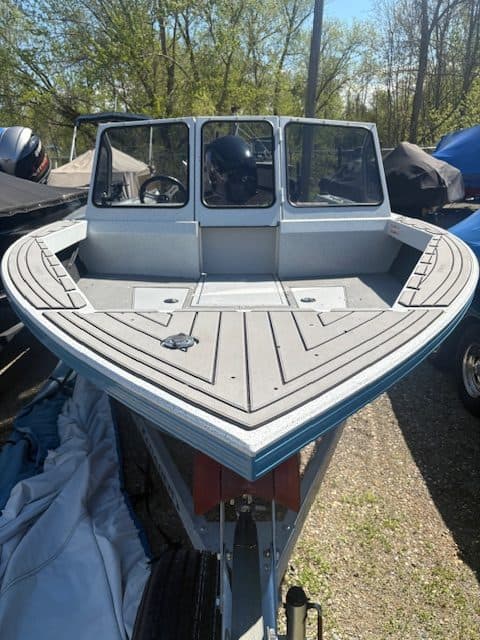 Fishing boat with cabin and wooden deck for freshwater or saltwater fishing.