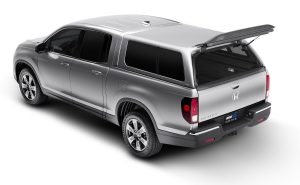 Silver Honda Ridgeline pickup truck with open bed and roof rack for outdoor gear.