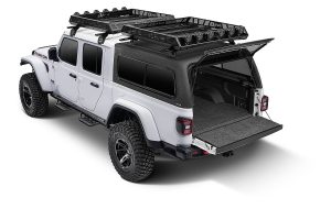 Detailed image of a rugged white Jeep Gladiator with off-road tires, roof racks, and open cargo bed, perfect for outdoor adventures.