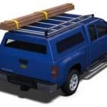 Heavy-duty blue pickup truck with roof racks and lumber on top, ideal for sports equipment transport.