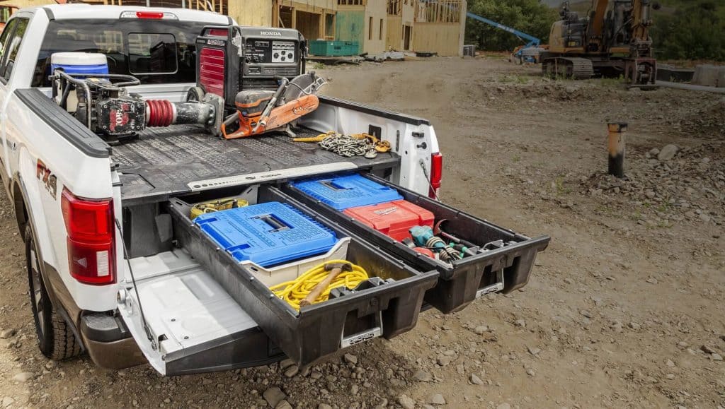 Construction tools and equipment organized in the truck bed at Camp & Cruise site.