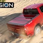 Red Ford F-150 pickup truck driving through sandy desert terrain.
