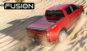 Red Ford F-150 pickup truck driving through sandy desert terrain.