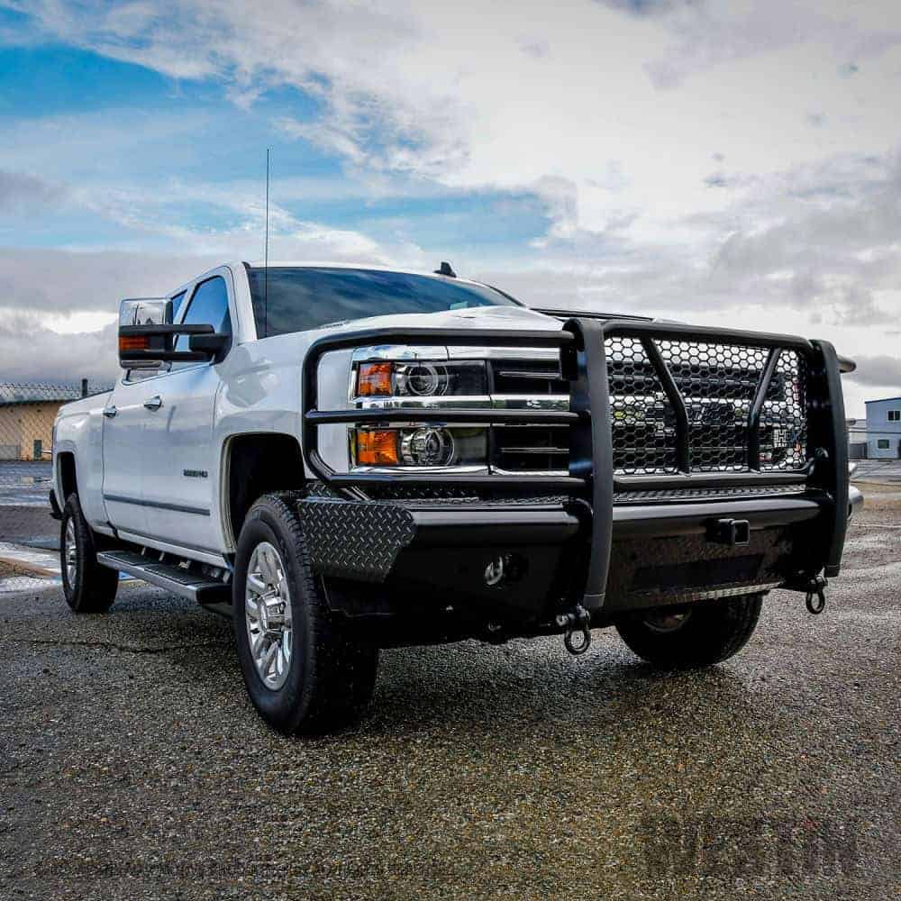 High-resolution image of a white heavy-duty utility truck with grille guard parked outdoors at Camp & Cruise.