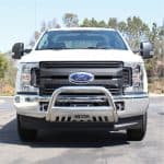 Front view of a white Ford pickup truck with a chrome bumper guard, showcasing durable vehicles.