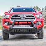 Bright red Toyota Tacoma with off-road bumper, emphasizing durability and power for outdoor sports.