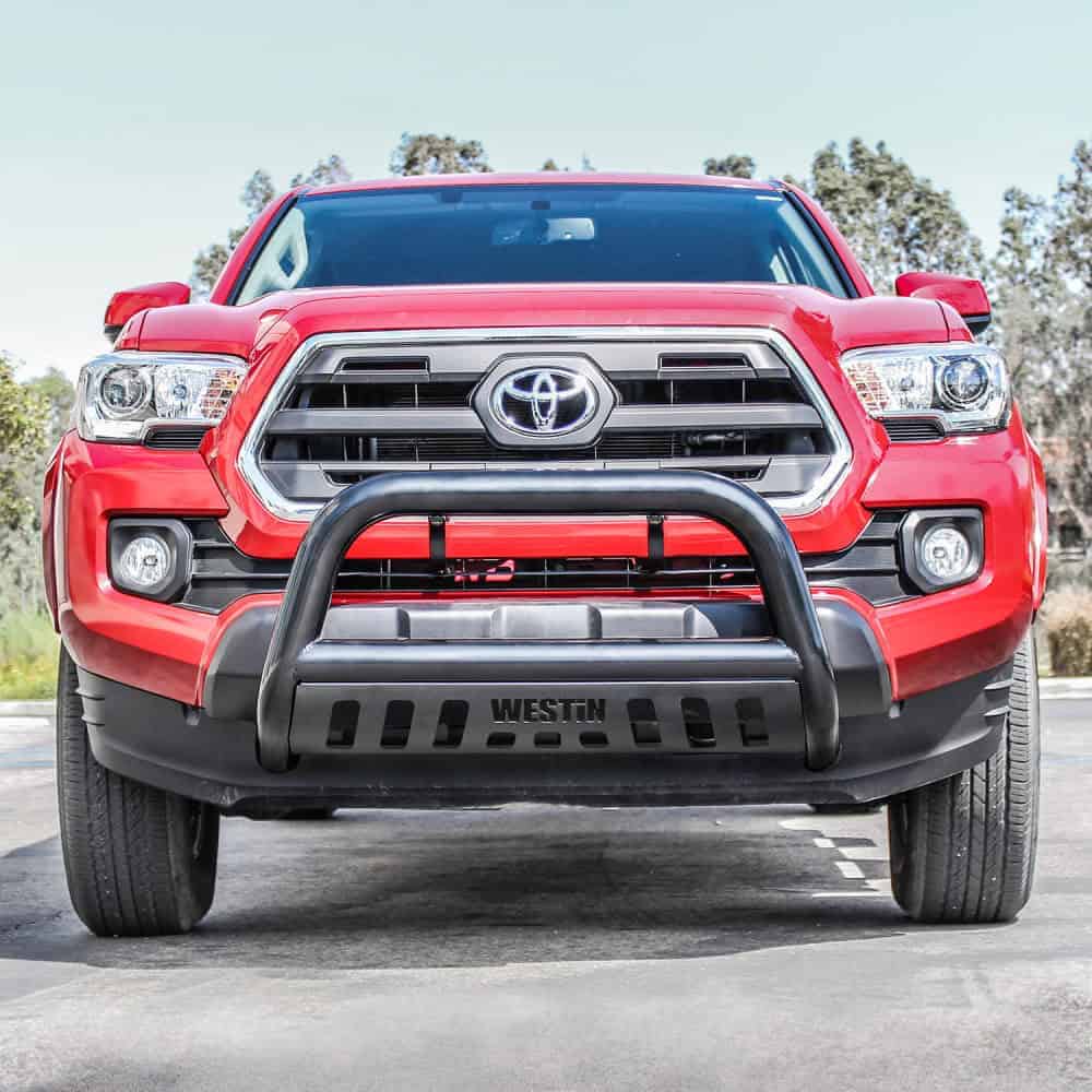 Bright red Toyota Tacoma with off-road bumper, emphasizing durability and power for outdoor sports.
