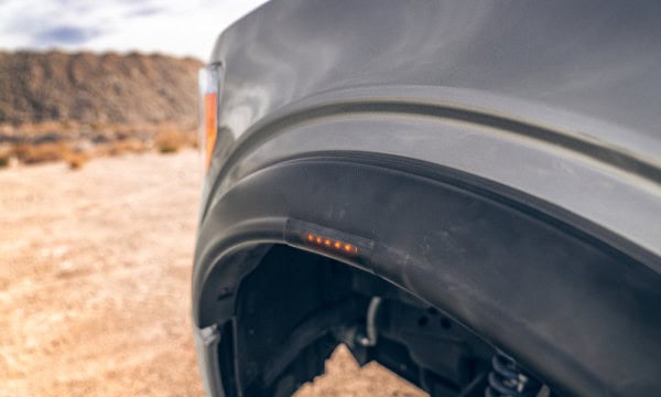 Close-up of an off-road vehicle's LED side light in a desert setting.