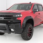 Red Chevrolet pickup truck with off-road tires, rugged design, and modern features.