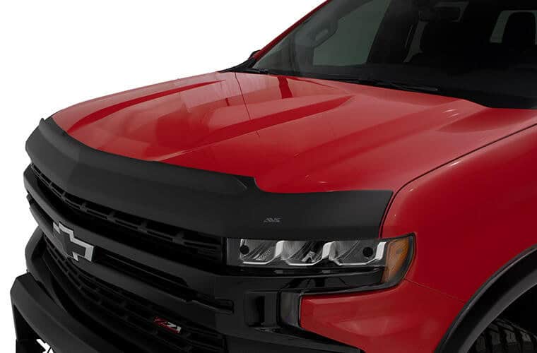 Close-up of a red Chevrolet truck with black grille and LED headlights.
