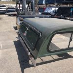 Durable green truck bed with canopy, ideal for outdoor sports equipment storage, on display at Camp & Cruise.