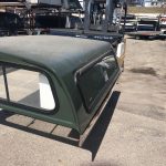 Durable green truck bed with black window frame, ideal for sports and outdoor use at Camp & Cruise.