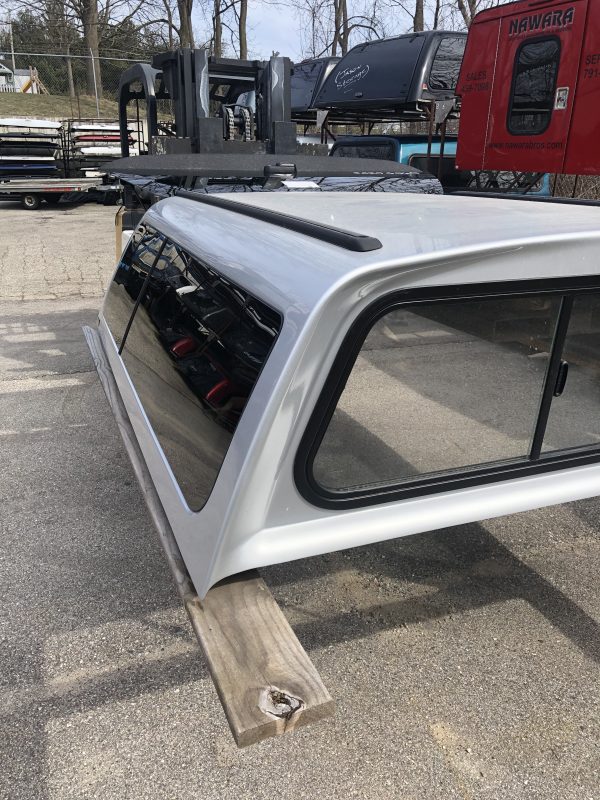 Custom silver garage door panel with tinted windows for sale at Camp & Cruise.