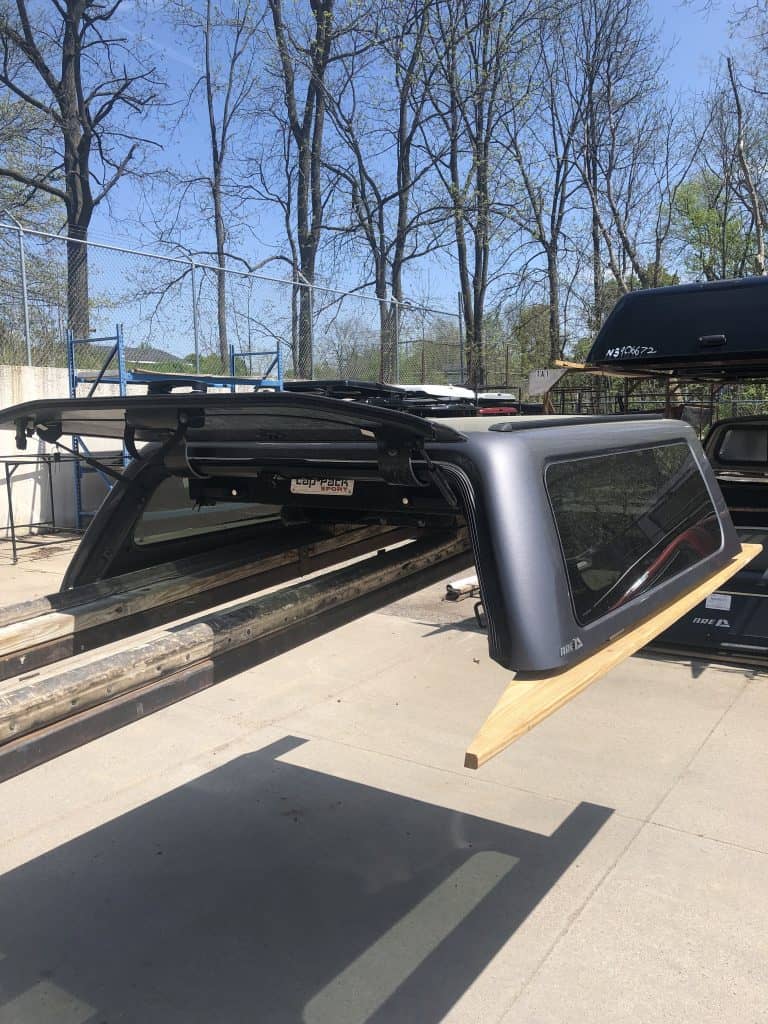 Lightweight truck camper shell with tinted windows at Camp & Cruise, ideal for outdoor adventures.