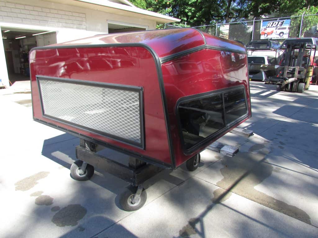 Durable red golf cart enclosure with side windows, ideal for outdoor sports center use.