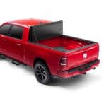 Red pickup truck with open bed and tonneau cover, showcasing vehicle accessories at Camp & Cruise.