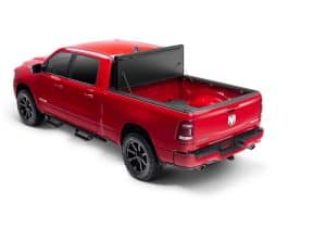 Red pickup truck with open bed and tonneau cover, showcasing vehicle accessories at Camp & Cruise.